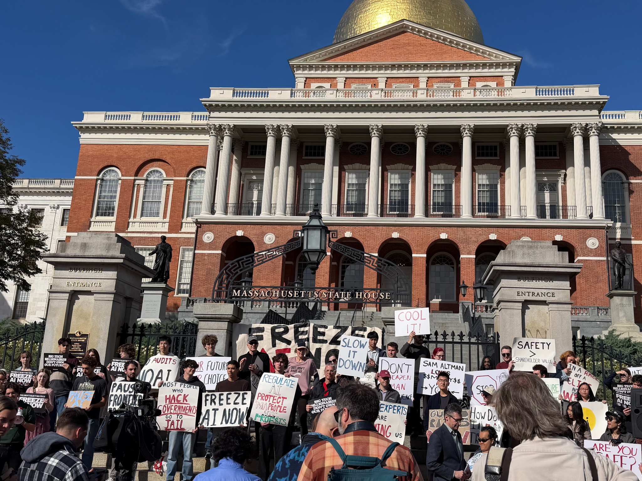 People gathered with AI safety signs outside the Massachusetts State House